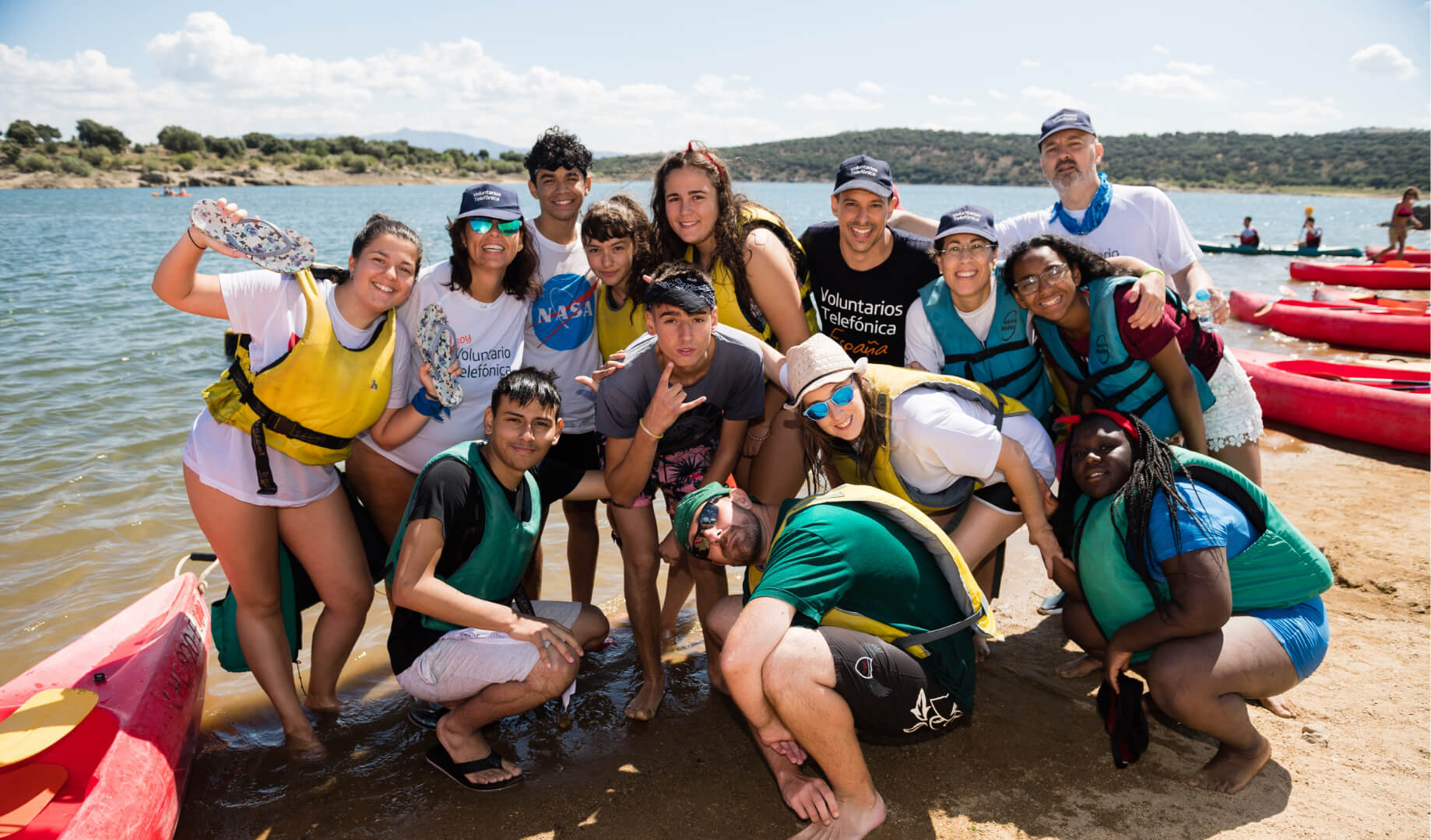 Voluntarios con unos chicos en un lago haciendo piragüismo