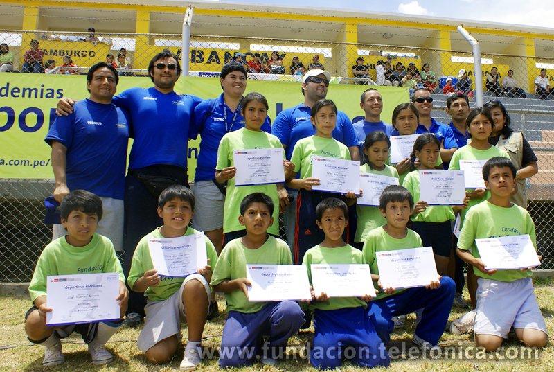 El coordinador técnico de la especialidad de atletismo, Eduardo Acuña, junto a su equipo técnico y un grupo de escolares de las I.E. Sagrado Corazón de Jesús y Divino Maestro de la ciudad de Abancay