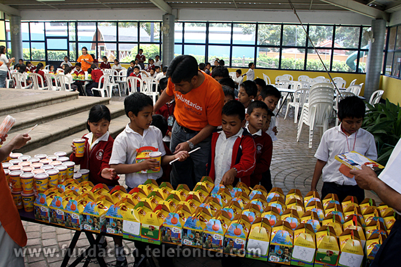 Los niños recibiendo su merienda para reponer energías.