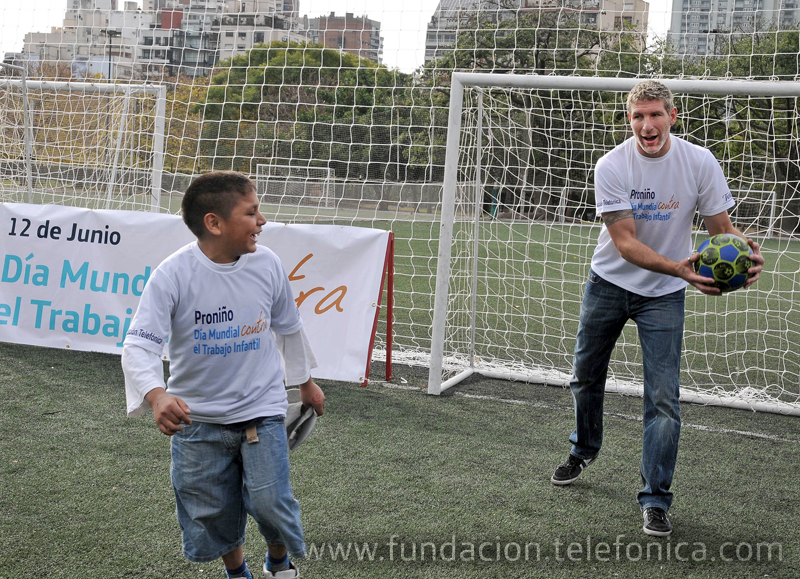 El futbolista Martín Palermo jugando con un beneficiario del programa Proniño.