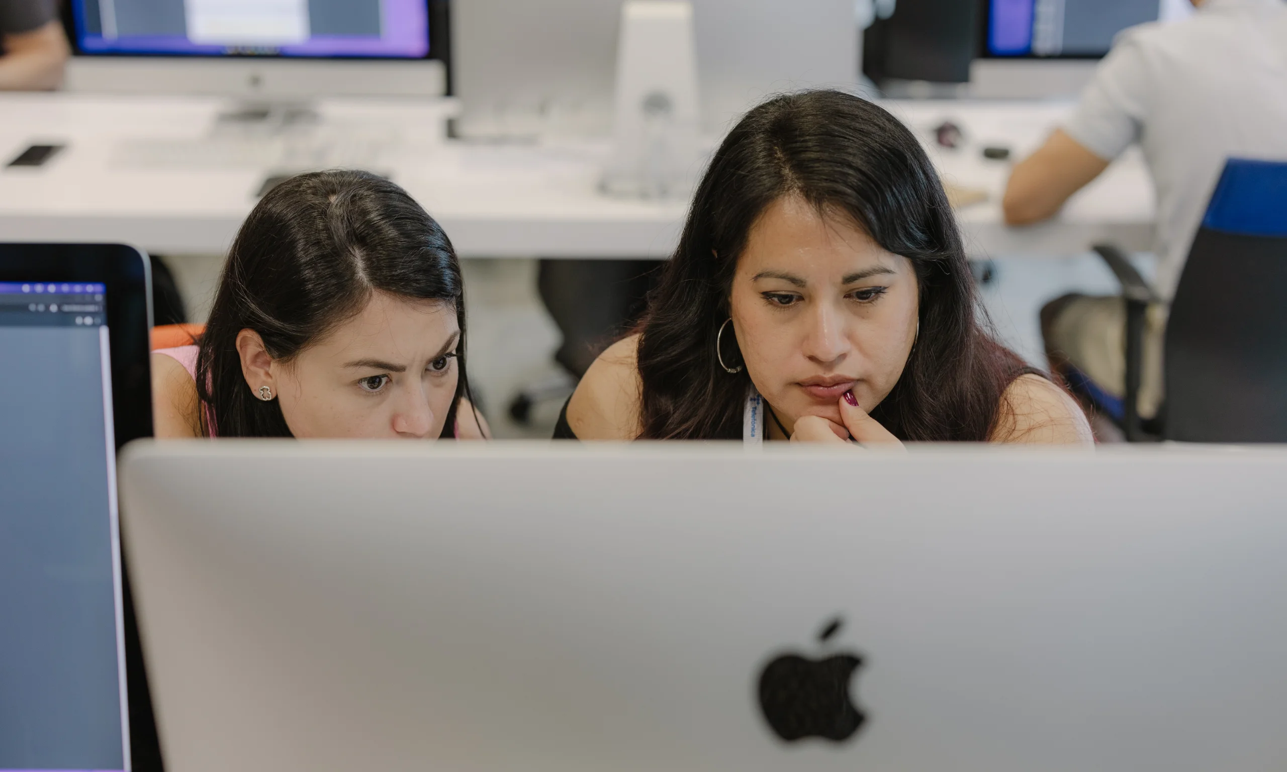 Dos mujeres ante un monitor en una de las piscinas de 42 en agosto de 2024
